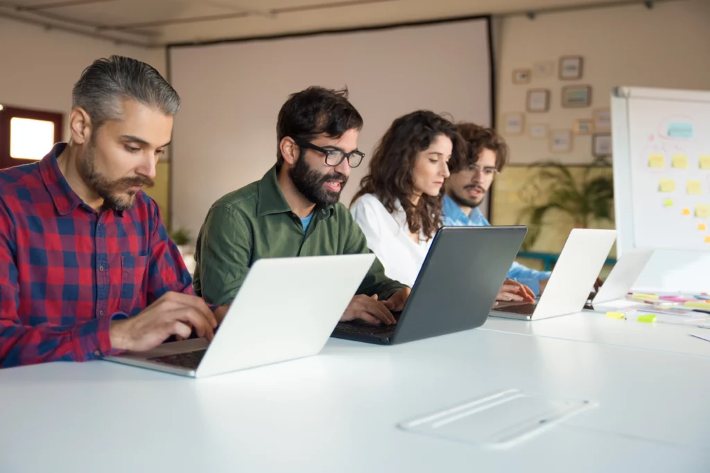 startup team collaborating project using laptops